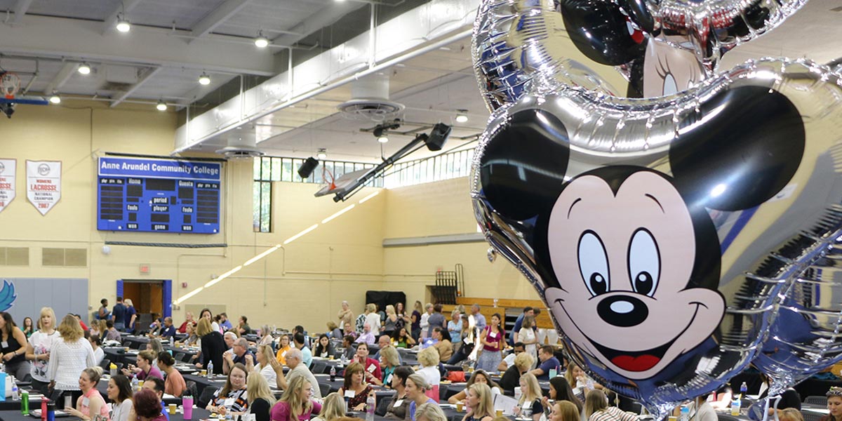 Mickey balloon with workshop attendees in the background.