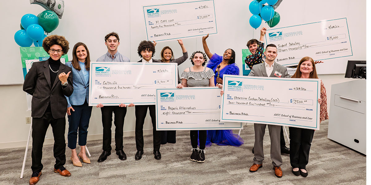 Winners of AACC's 2026 Business Pitch Competition hold large checks and celebrate.