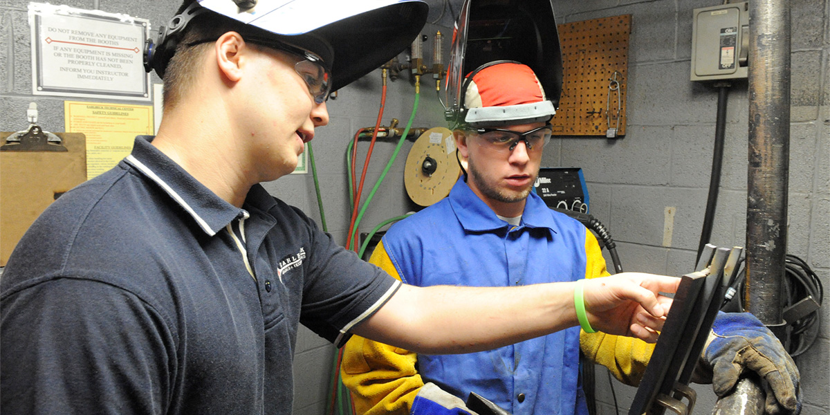 AACC welding student receives instruction.
