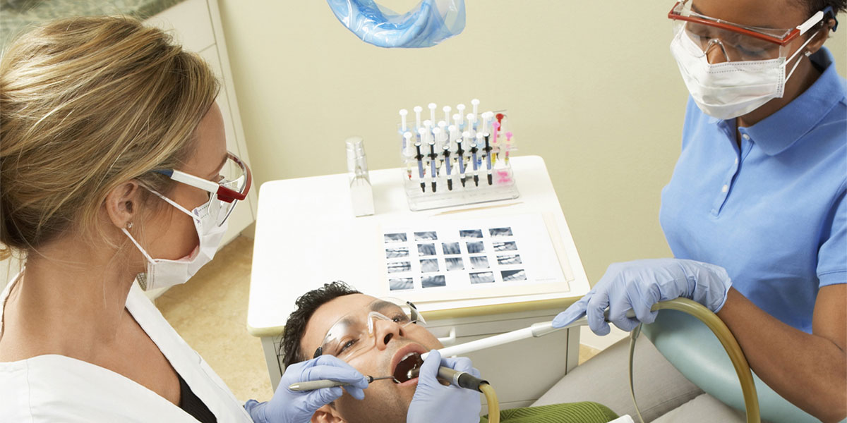 Dentist and dental assistant with patient 