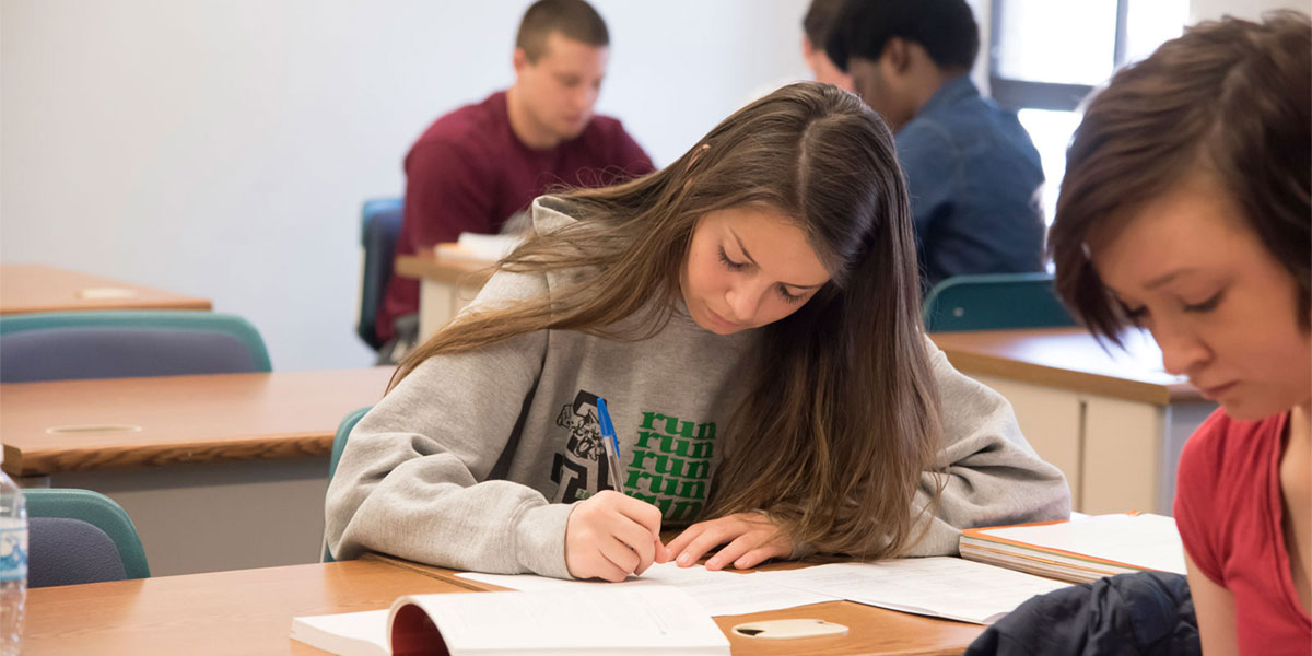 AACC student working at her classroom desk