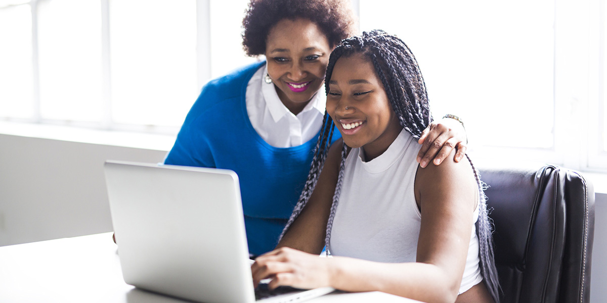 Mom and student look at computer.