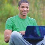 Student work on his computer outside.