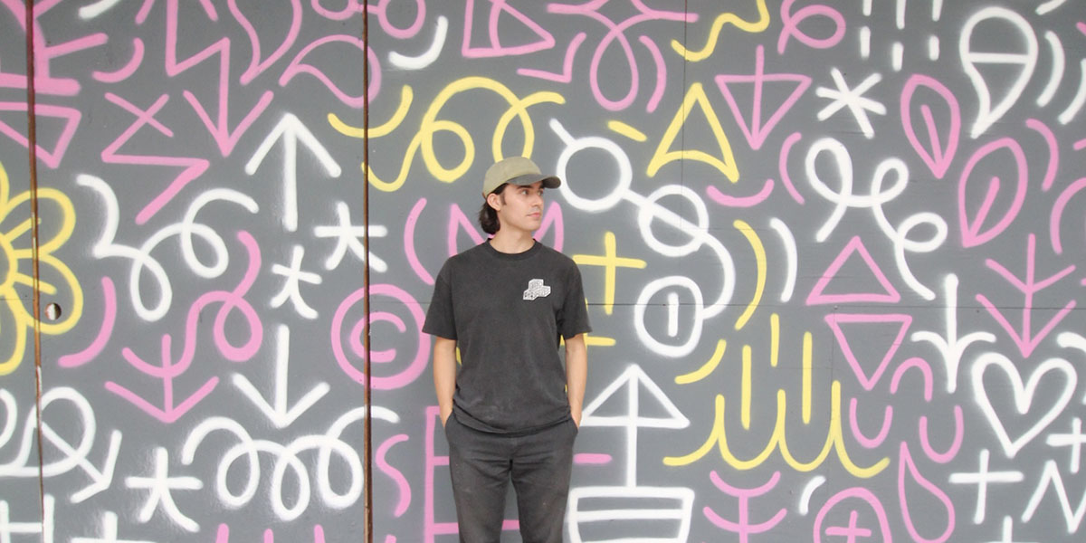 Vinnie Hager standing in front of his artwork