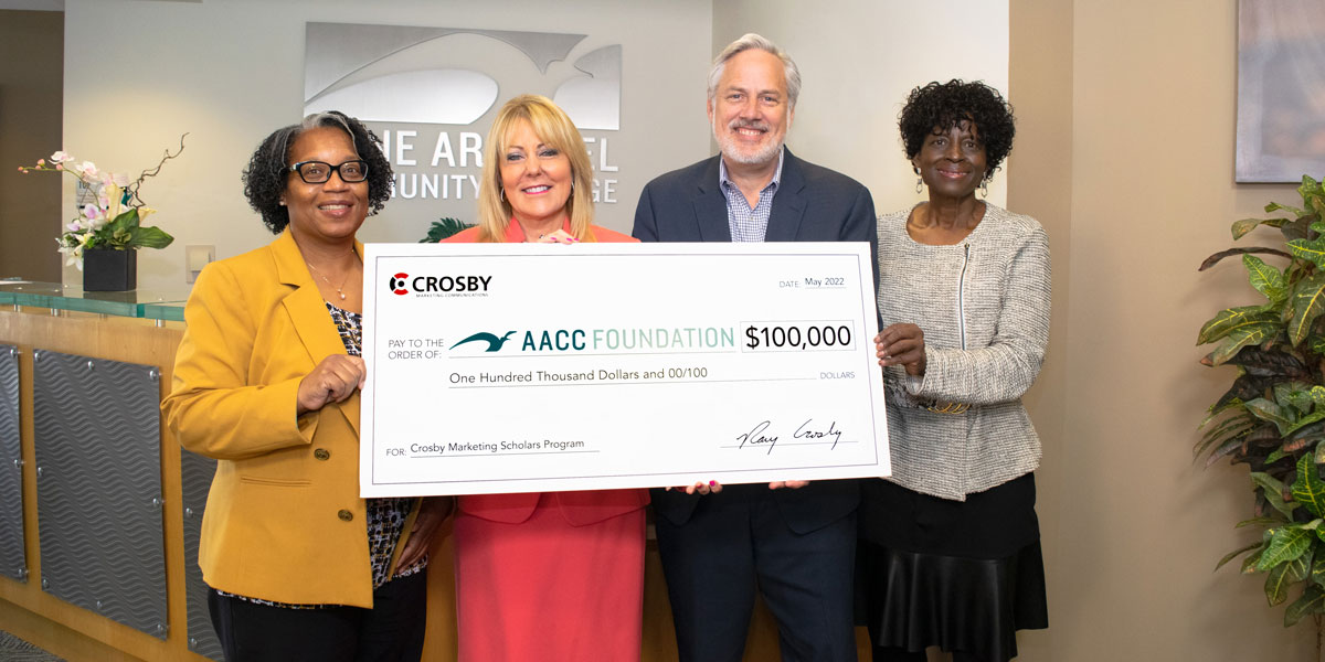 Image of Crosby and AACC employees holding large check for Crosby Scholarship.