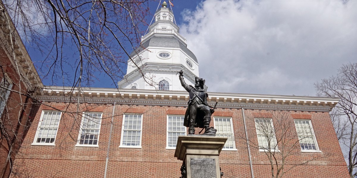 The capitol building in Annapolis with a statue in front of it