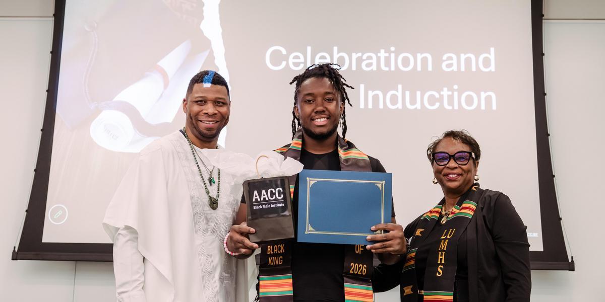 Johnathan holding a certificate during the Sankofa Send Off event with AACC staff.