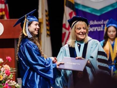 Katie Cortina receiving her diploma from Dr. Dawn Lindsay during the 2026 commencement ceremony.