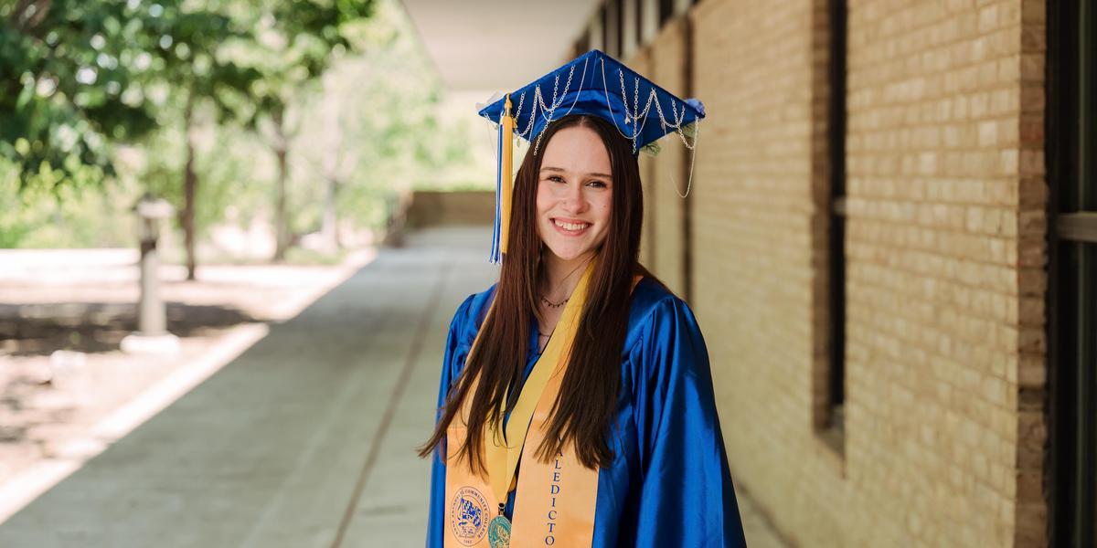 Rebecca posing in graduation garb.