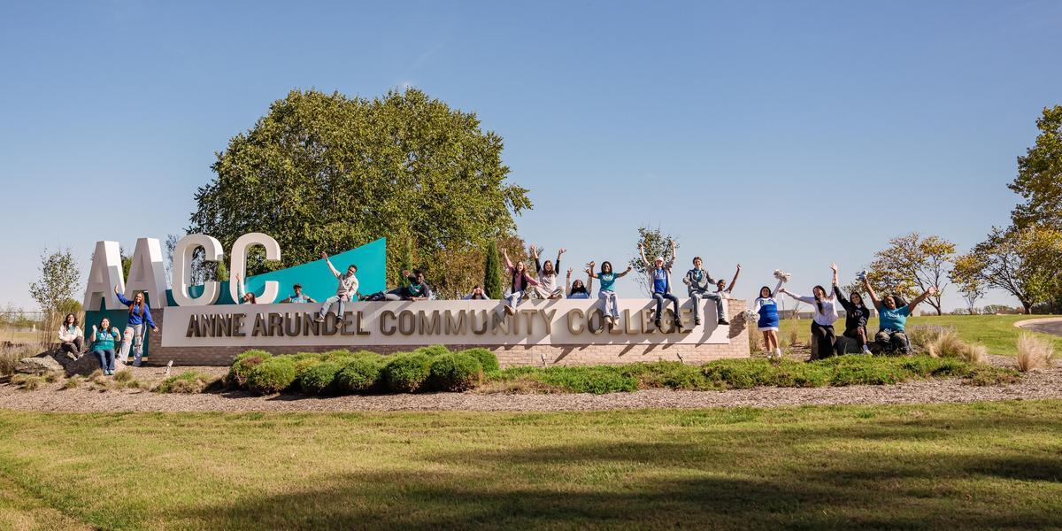 AACC Entrance Sign with students surrounding it.