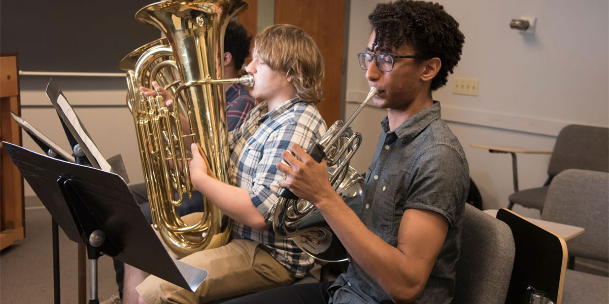 AACC students playing brass instruments in a classroom.
