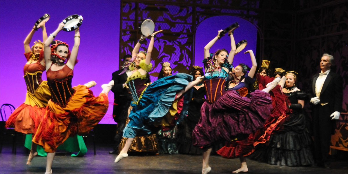 AACC students perform on stage in colorful costumes.