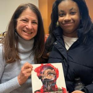 Instructor and student presenting art project.
