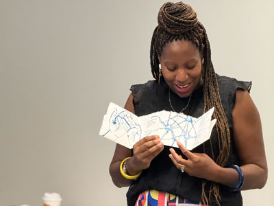 Instructor showing art piece.
