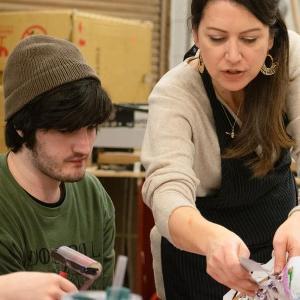 Instructor working with student on art project.