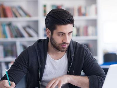 Student studies using his computer.