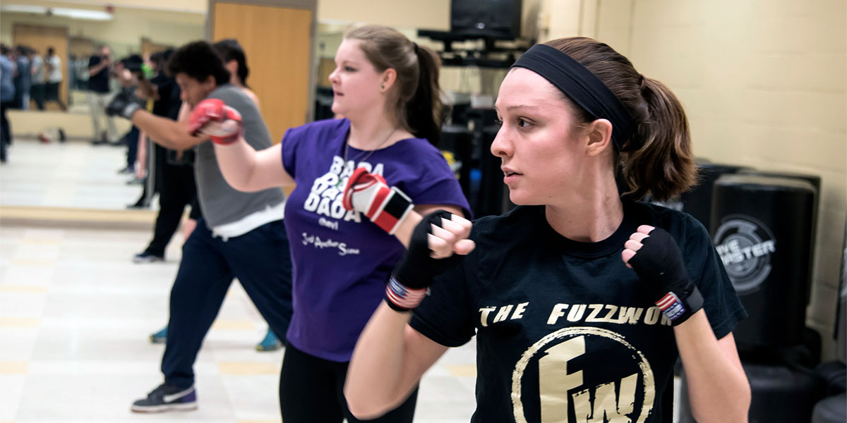 women in class practicing self defense 