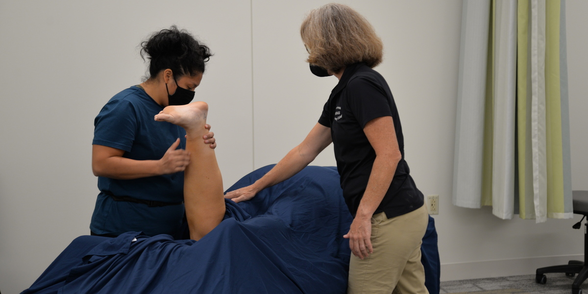 Massage student giving a massage with instructor.