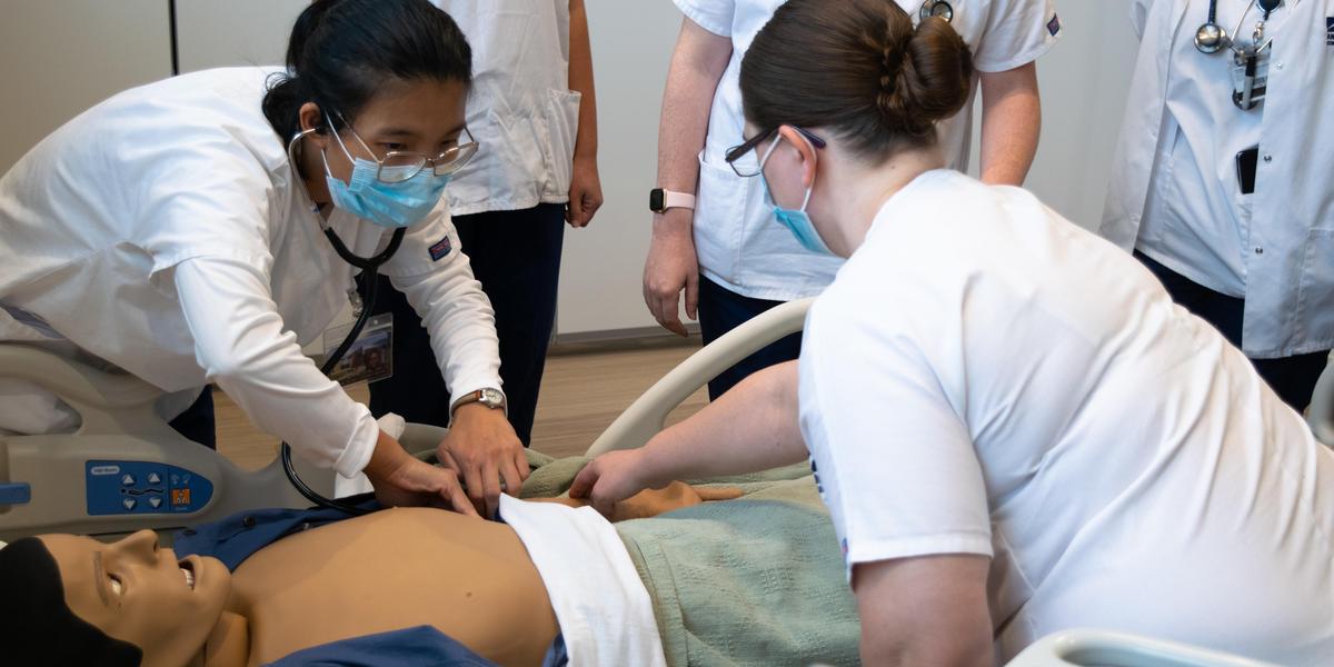 Nursing students in lab instruction.