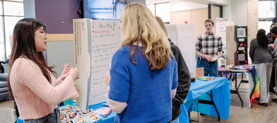 A student presents her poster for a public health class.