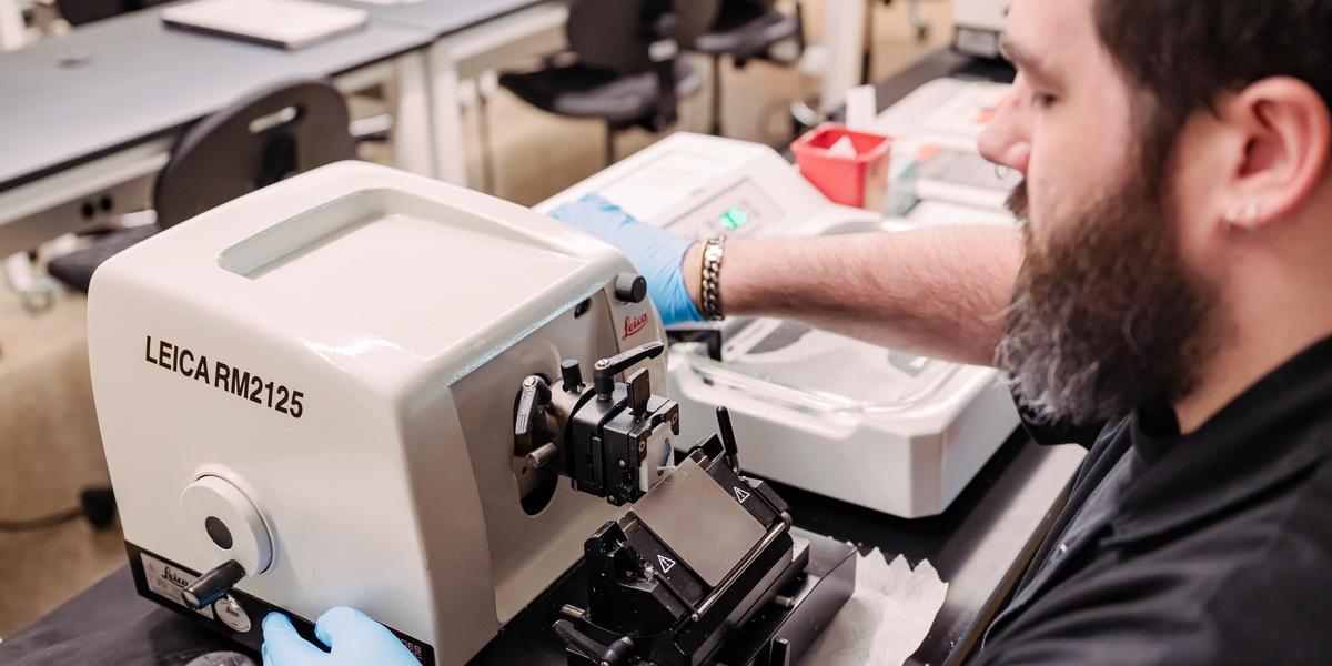 A student using a machine for the histotechnician program