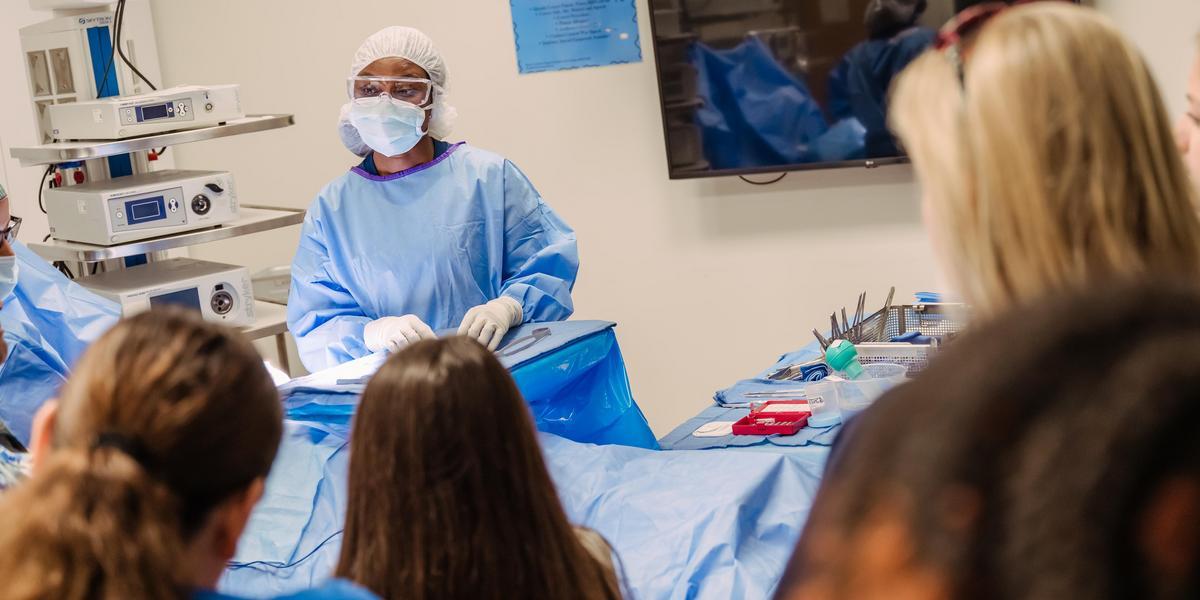 Surgical technology demonstration with prospective students watching.