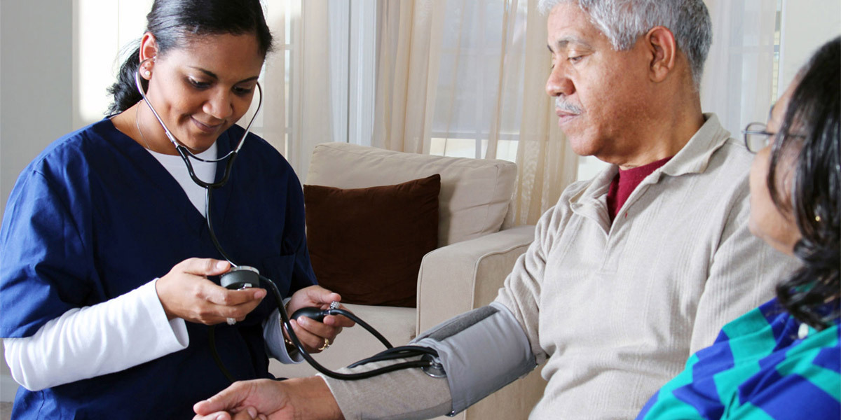 Health professional taking a senior's blood pressure.