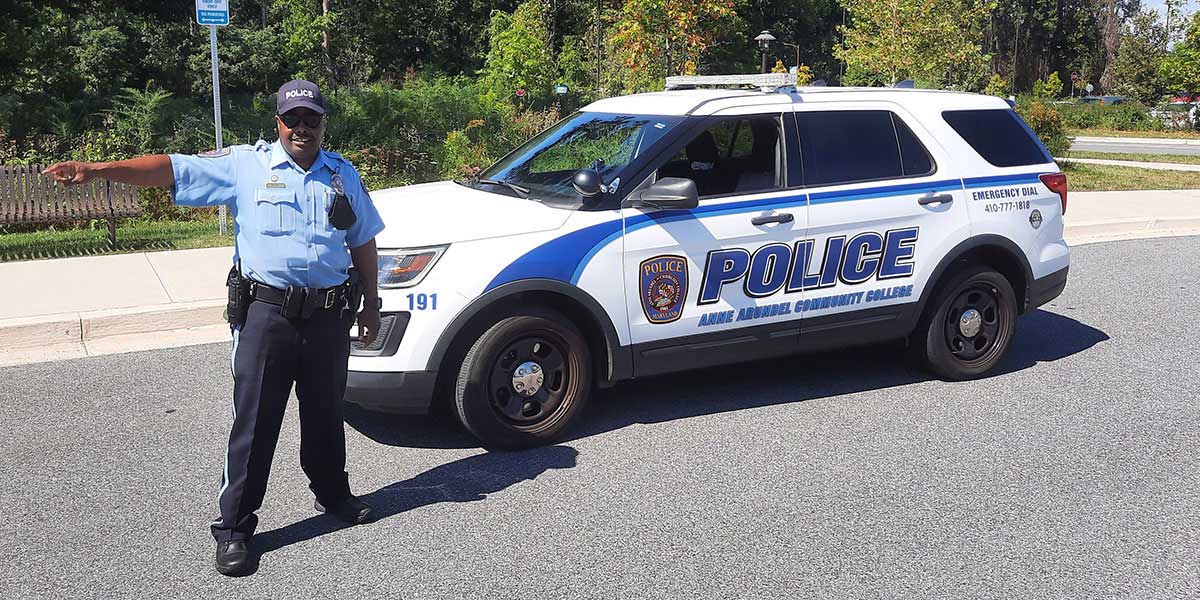 Department of Public Safety officer standing in front of patrol car