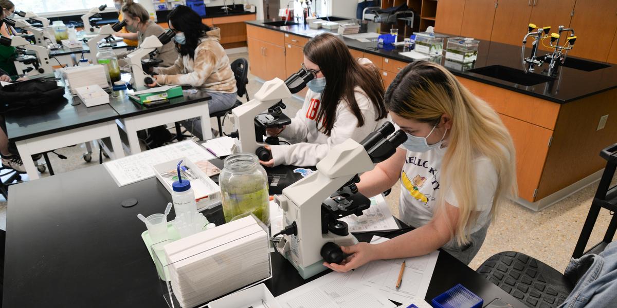 Students inspecting item in Biology class.