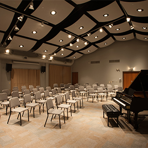 CADE Rehearsal space with chairs and piano.