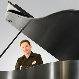 Headshot of Jerry Ascione next to a piano