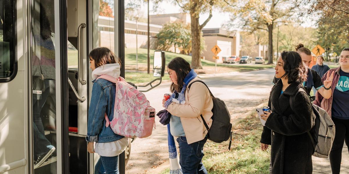 AACC students walking onto bus.