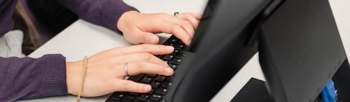 Student typing on a keyboard