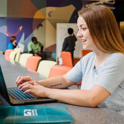 Student using computer on AACC campus.