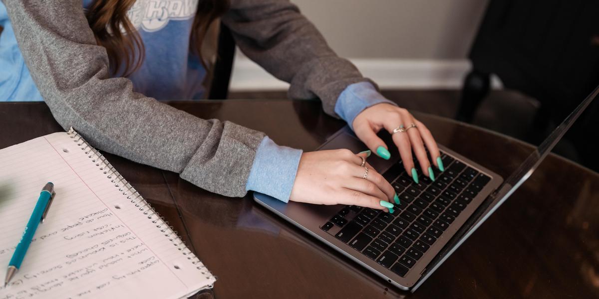 Student typing in a keyboard.