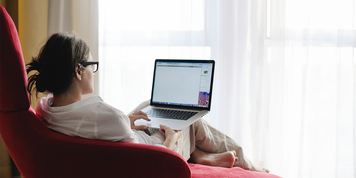 Female student attends class on her laptop at home.