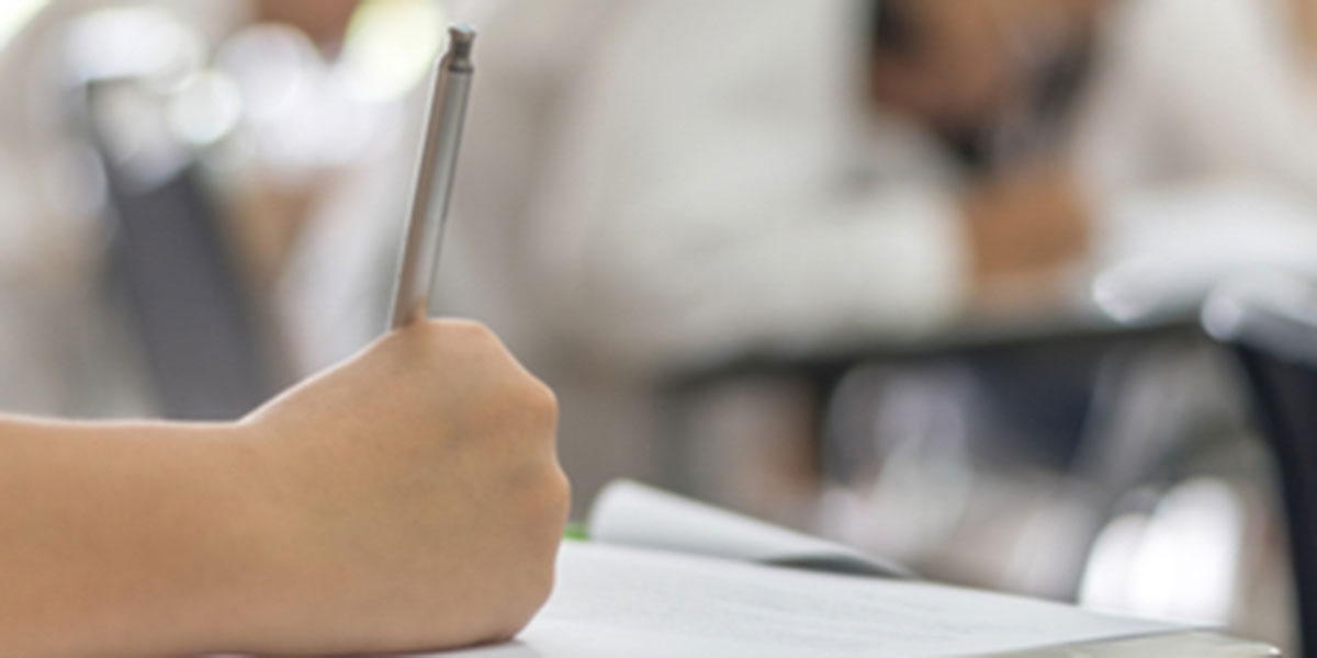 Student hand writing on paper