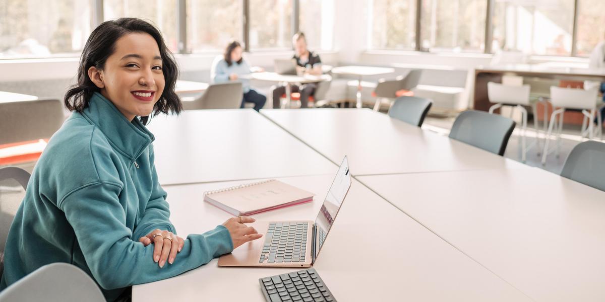 Student smiling for camera while in conference room.