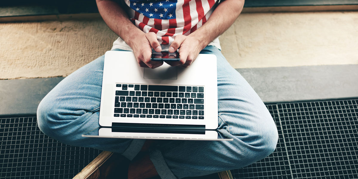 Man in American flag shirt on his laptop.