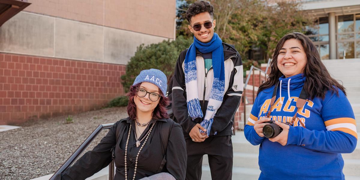 Group of students smiling outside in amphitheater.