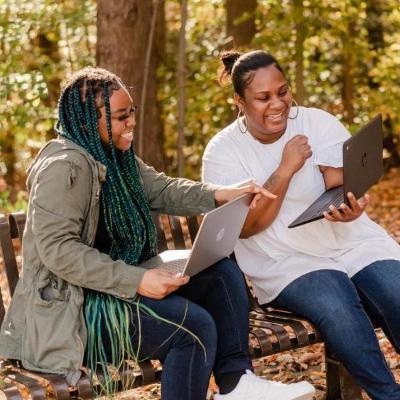 Two students at Arnold campus during the fall term on laptops.