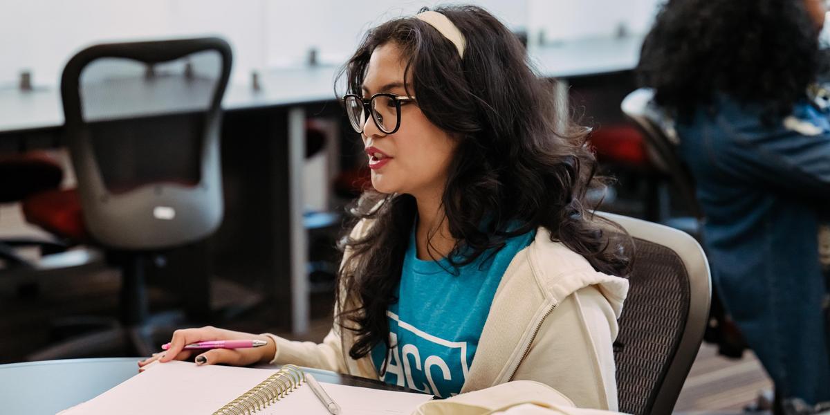 Student sitting at a desk with a notebook.